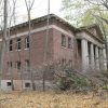 <p><strong>Neoclassical, details</strong>: Formal symmetry and projecting center pavilion with full-height porch. Administration Building (Building 13), view northwest, November 2005.</p>